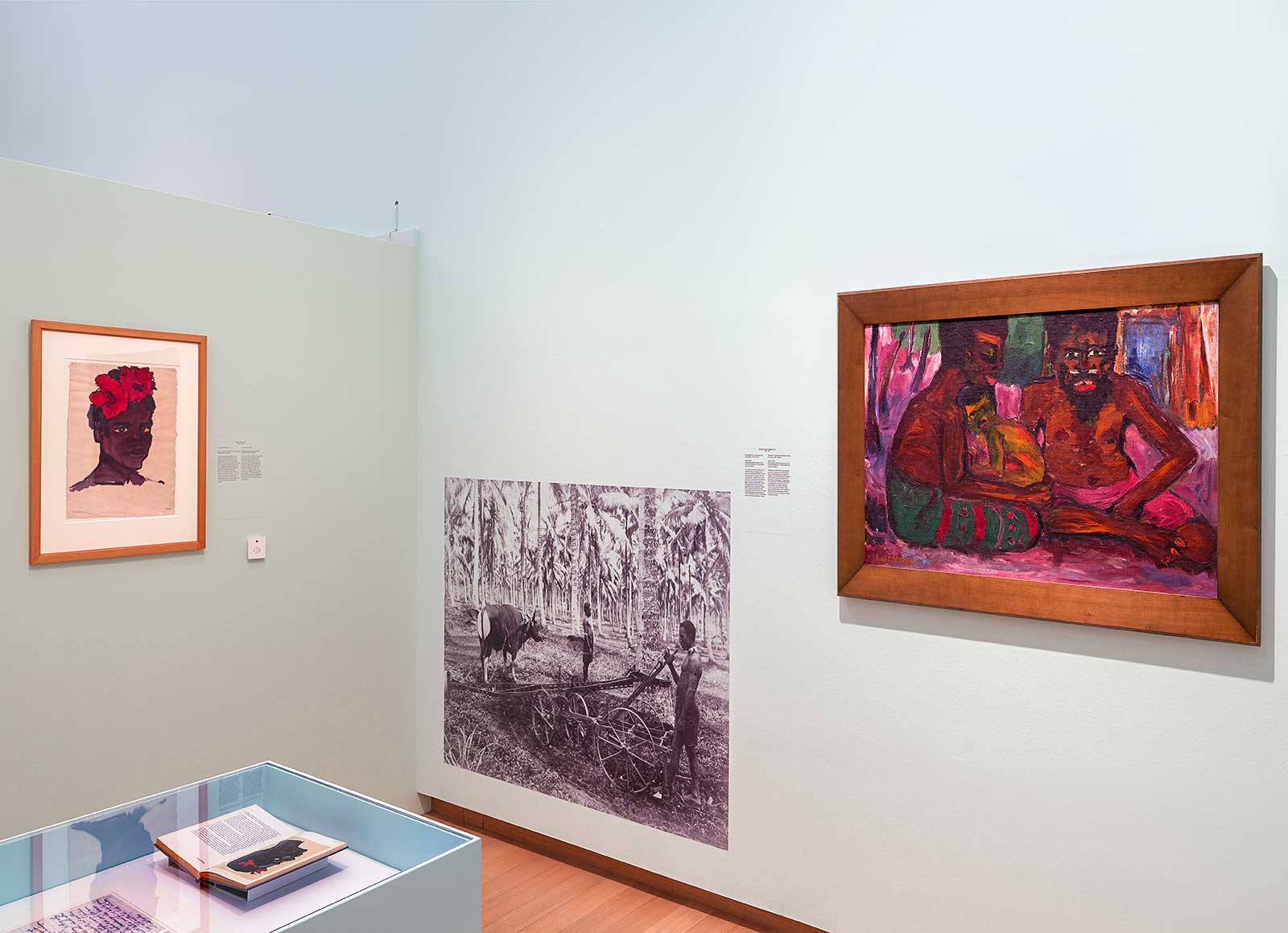 Fig. 3 Exhibition view of Kirchner and Nolde: Expressionism. Colonialism. at Stedelijk Museum Amsterdam, 2021. Juxtapositions of Nolde’s New Guinea artworks with contemporaneous photographs. Photo: Gert-Jan van Rooij. Left to right: Emil Nolde, Jupualo, 1913–14, watercolor and India ink on paper, 47.4 x 34.9 cm, Nolde Foundation Seebüll; Heinz von Sigriz, Plantation Cultivator of the New Guinea Company, 1912–13, reproduction Photography Collection Museum Fünf Kontinente, Munich; Emil Nolde, Familie, 1914, oil on canvas, 71 x 105 cm, Nolde Foundation Seebüll.