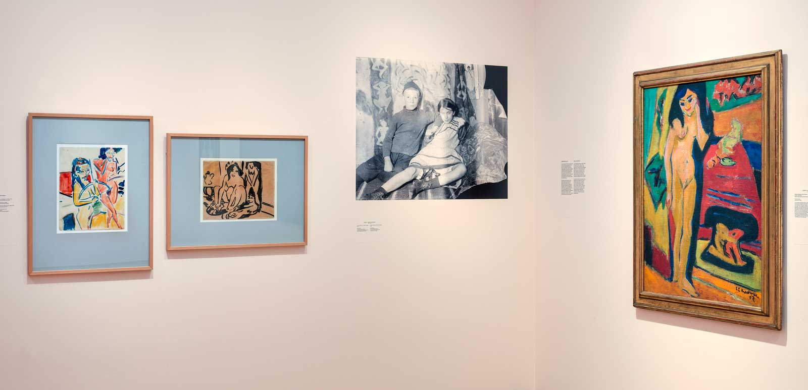 Exhibition view of Kirchner and Nolde: Expressionism. Colonialism, 2021, photo by Gert-Jan van Rooij, © Stedelijk Museum Amsterdam. Left to right: Ernst Ludwig Kirchner, Fränzi mit Bogen und Akt, 1910, watercolor on paper, 45 x 35 cm. Brücke-Museum, Berlin; Ernst Ludwig Kirchner, Hockender Mädchenakt, 1909-1910, ink on paper, 34 x 44 cm, Brücke-Museum, Berlin; Ernst Ludwig Kirchner’s photograph of Fränzi Fehrmann and Peter, Dresden, 1910, photograph, 13 x 18 cm, donation of the Estate of Ernst Ludwig Kirchner, 2001, Kirchner Museum Davos; Ernst Ludwig Kirchner, Nacktes Mädchen hinter Vorhang (Fränzi), 1910-1926, oil on canvas, 120 x 90 cm, Stedelijk Museum Amsterdam.