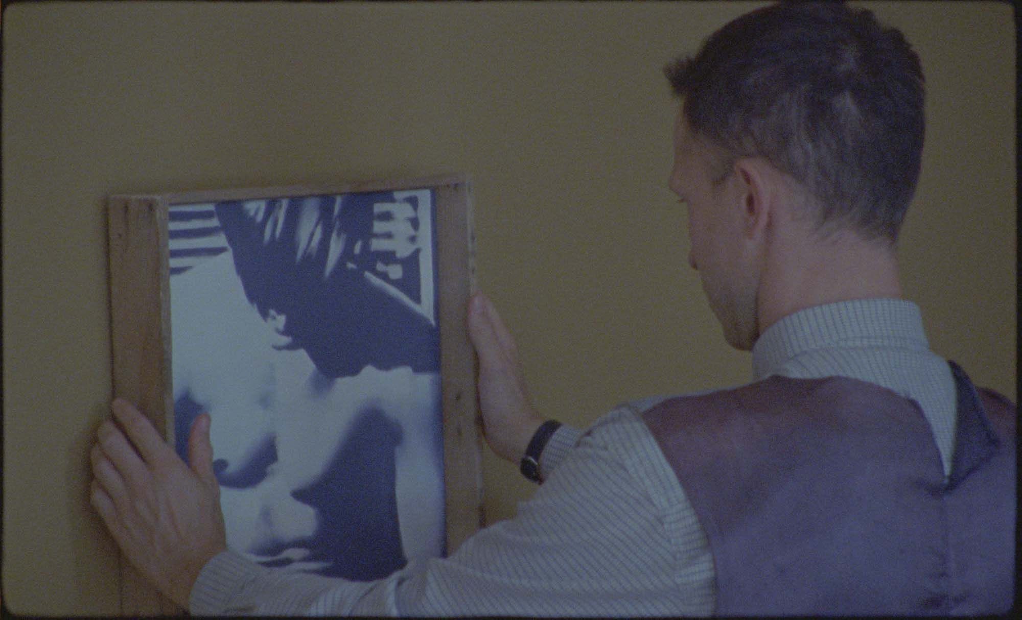 Wilhelm Sasnal, The Assistant, 2024, film still. Seen in the film still is Wilhelm Sasnal’s Untitled (after “The Smiths” album cover), 2023, oil on canvas, incl. frame: 37 × 38 cm. Courtesy the artist and Foksal Gallery Foundation.