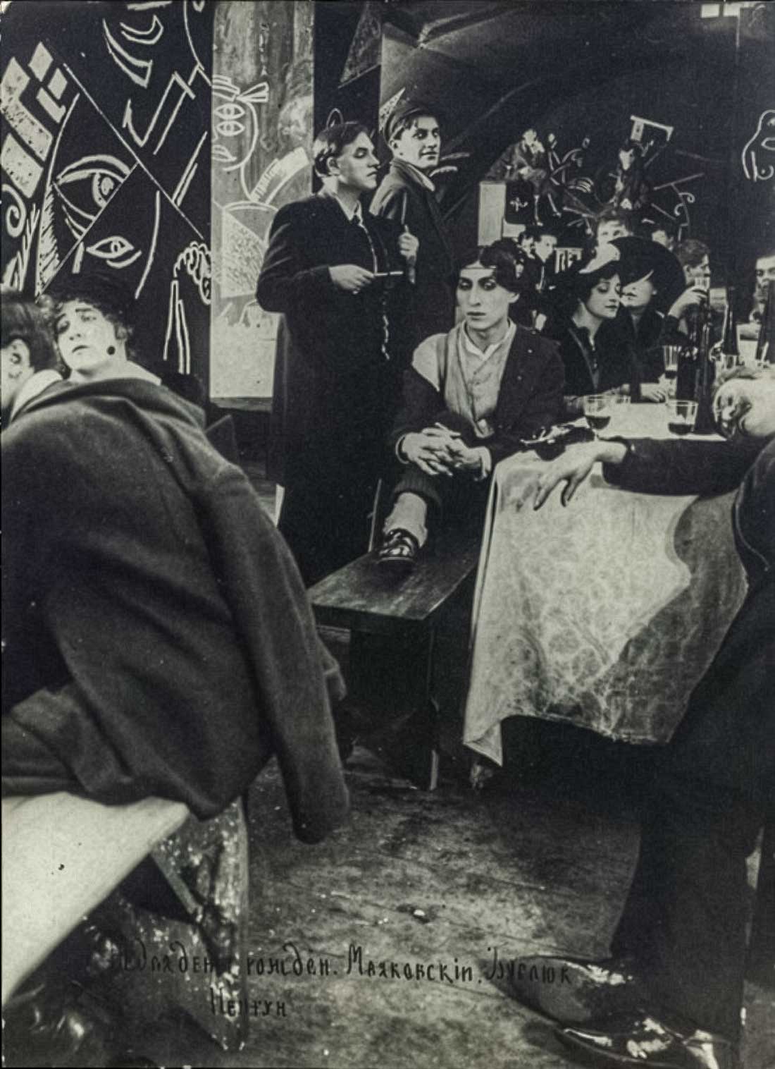 Fig. 10. Still from the film Ne dlya deneg rodivshiysya (Not Born for Money), 1918. Poets David Burliuk (holding a lorgnette and a notepad) and Vladimir Mayakovsky are shown standing in the setting of a poetry café, decorated by Futurists. Photograph by E.O. Slavinsky. From the collection of the State Mayakovsky Museum, Moscow. Retrieved from: State Mayakovsky Museum.