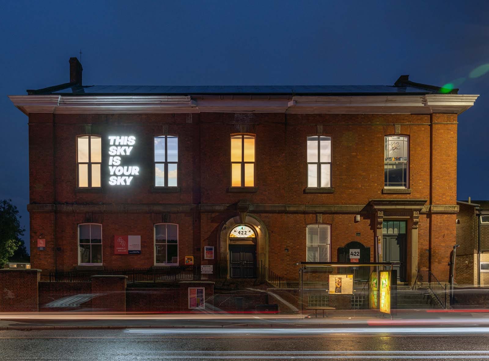 Figure 3. Bill Balaskas, This sky is your sky, 2024. LED light installation and window films on the facade of the 422 Community Hub, Manchester, 2.6 x 1.6 m. Created through an open-ended collaboration process based on voting, consultation, deliberation, editing, and selection led by the communities of 422, this illuminated sign was curated by Or Tshuva.